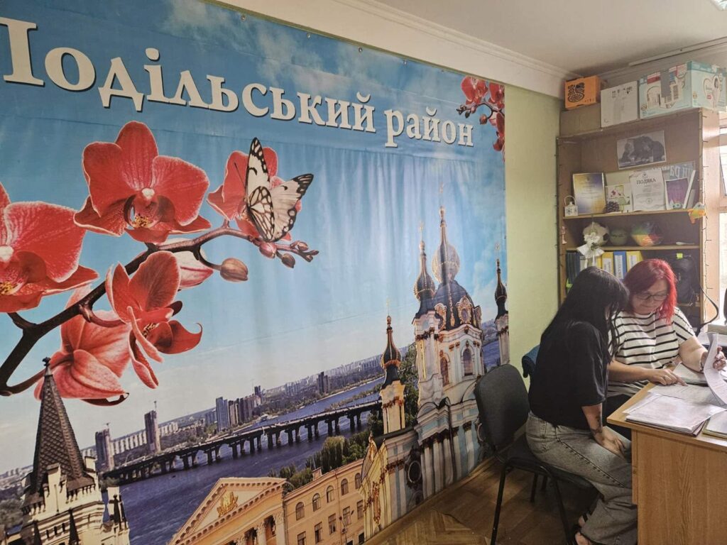 На фото спеціаліст Центру в офісі оформлює документи з отримувачем соціальних послуг 