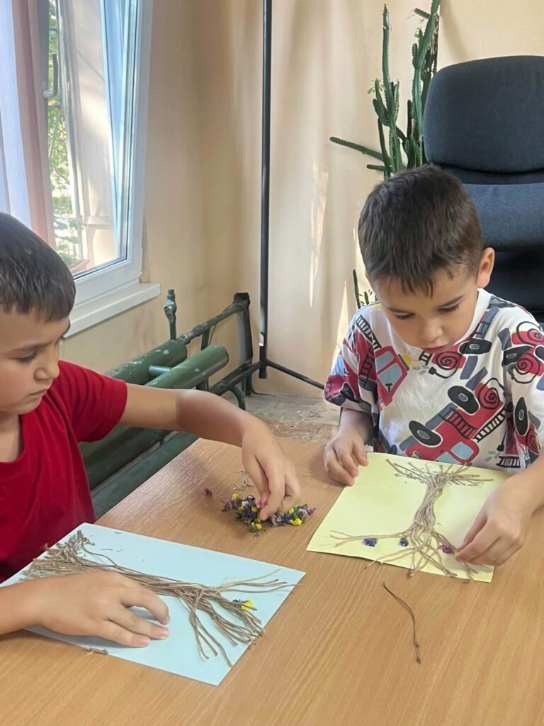 На фото діти виконують дерево із сухоцвітів